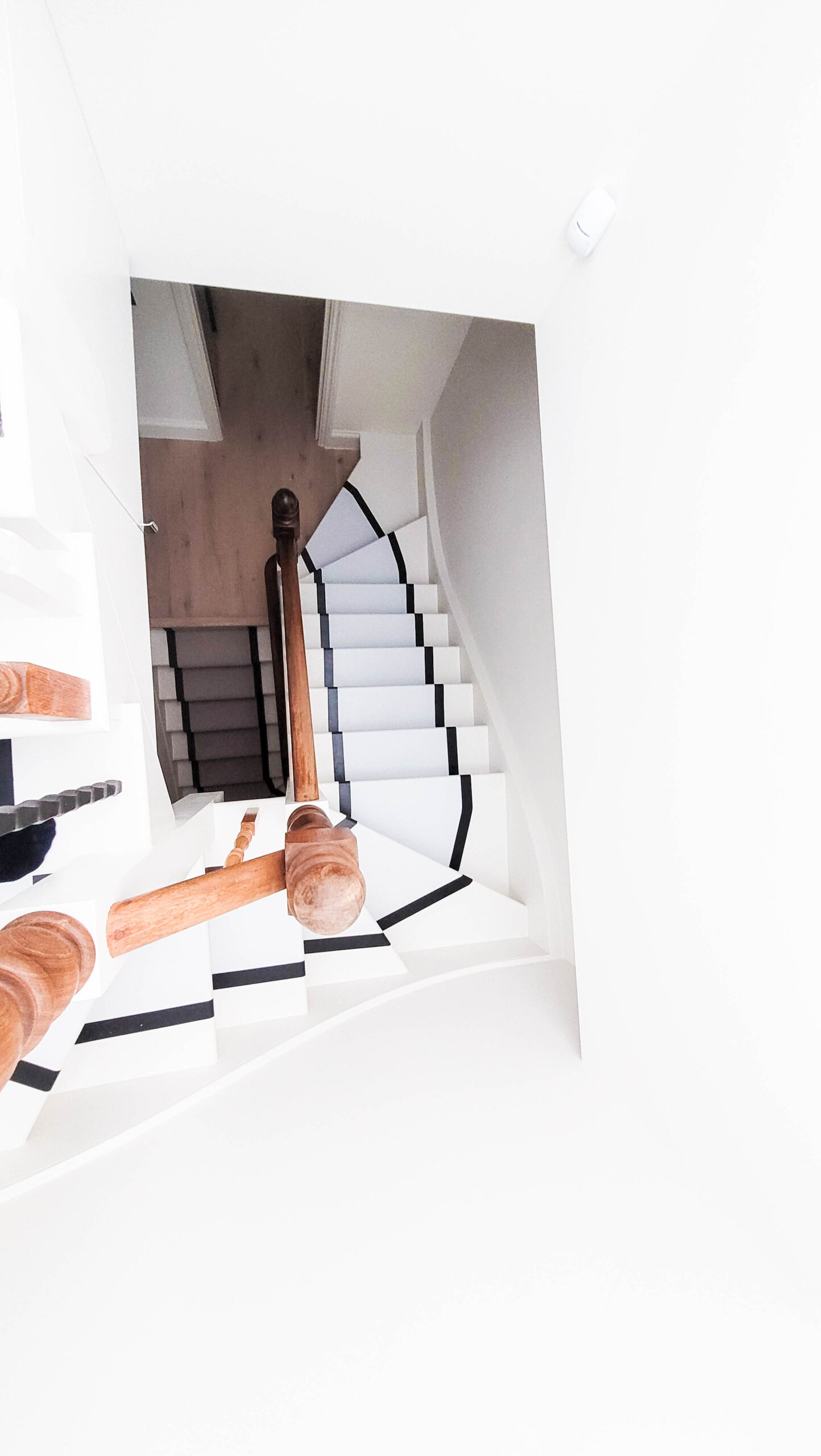 Bright white spiral staircase with wooden railings.