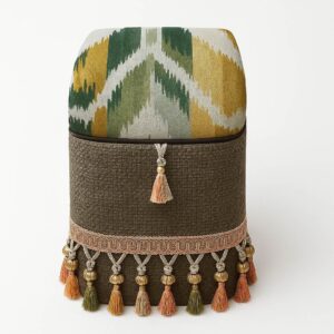 Colourful upholstered footstool with tassels and patterns.