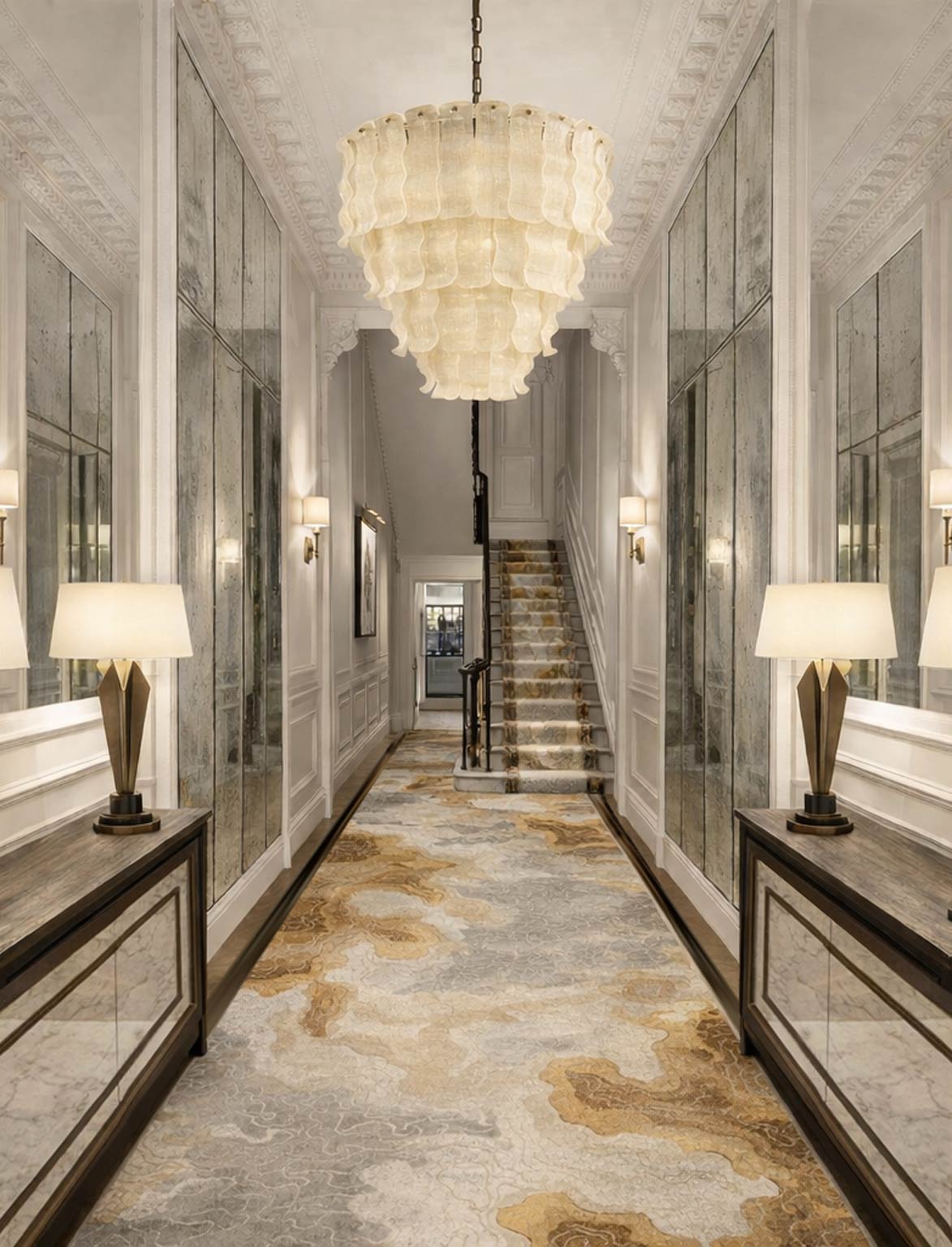 Luxurious hallway with ornate chandelier and mirrored walls.